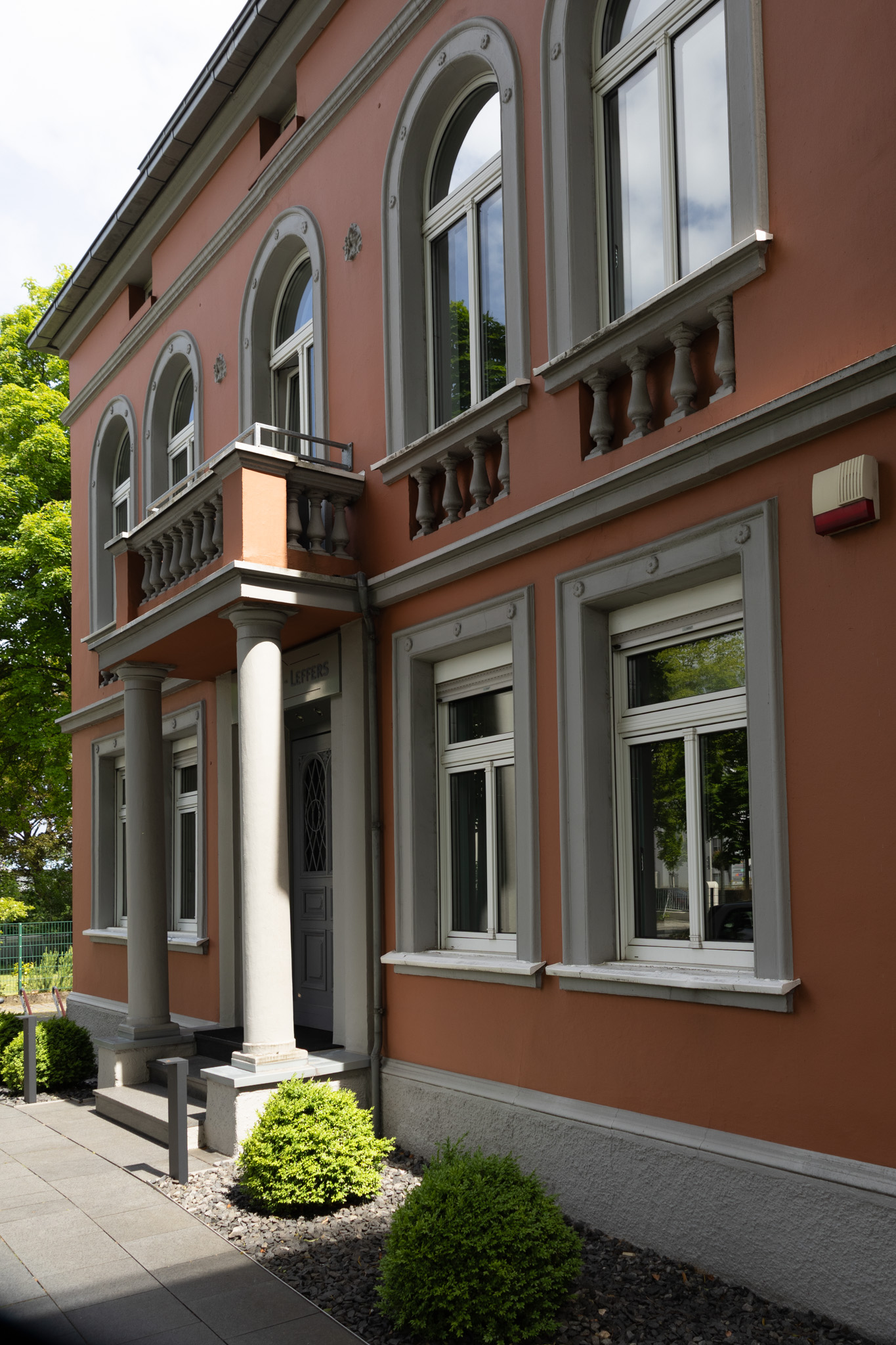 Gebäude-1 Zwei Geschäftsleute in Anzügen arbeiten an Immobilienprojekten mit Architekturmodellen und Vertragsdokumenten.